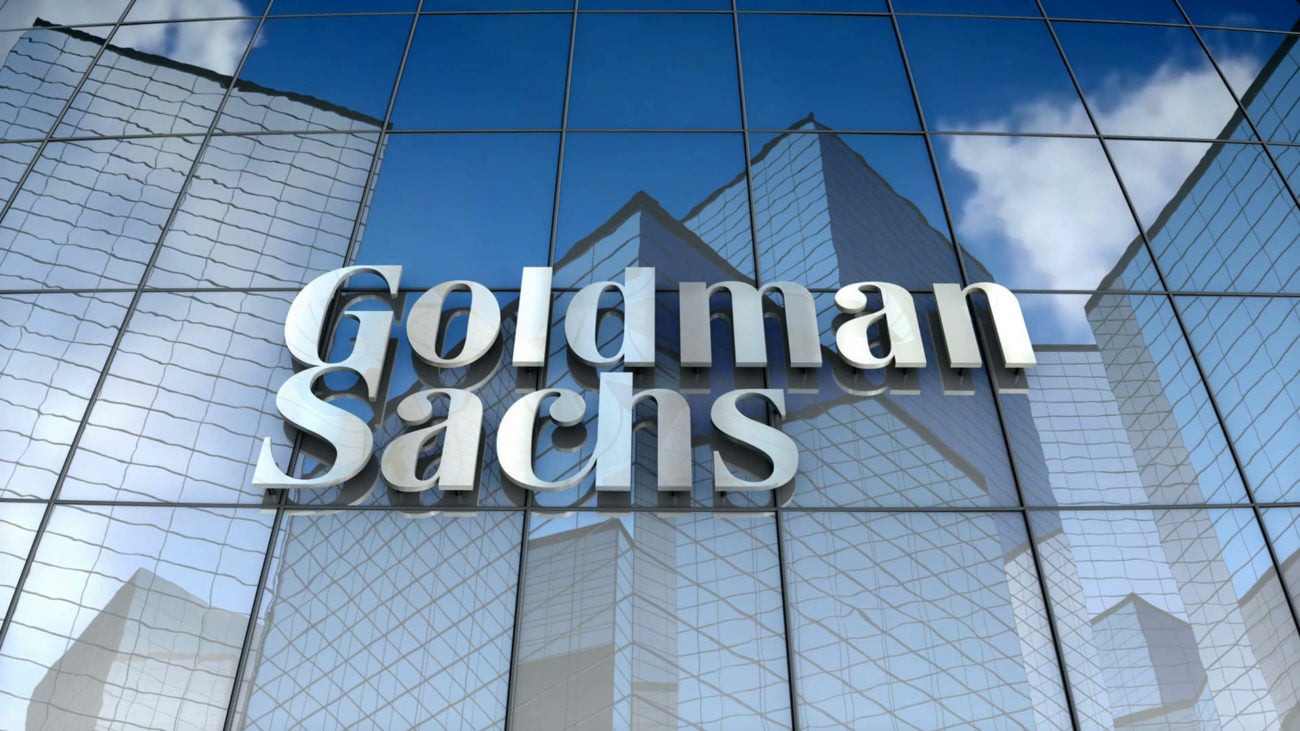The goldman sachs logo sits against a mirrored building
