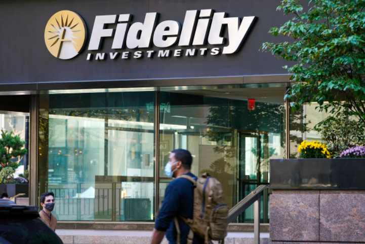 Some customers walk by a fidelity bank building sitting in the sun
