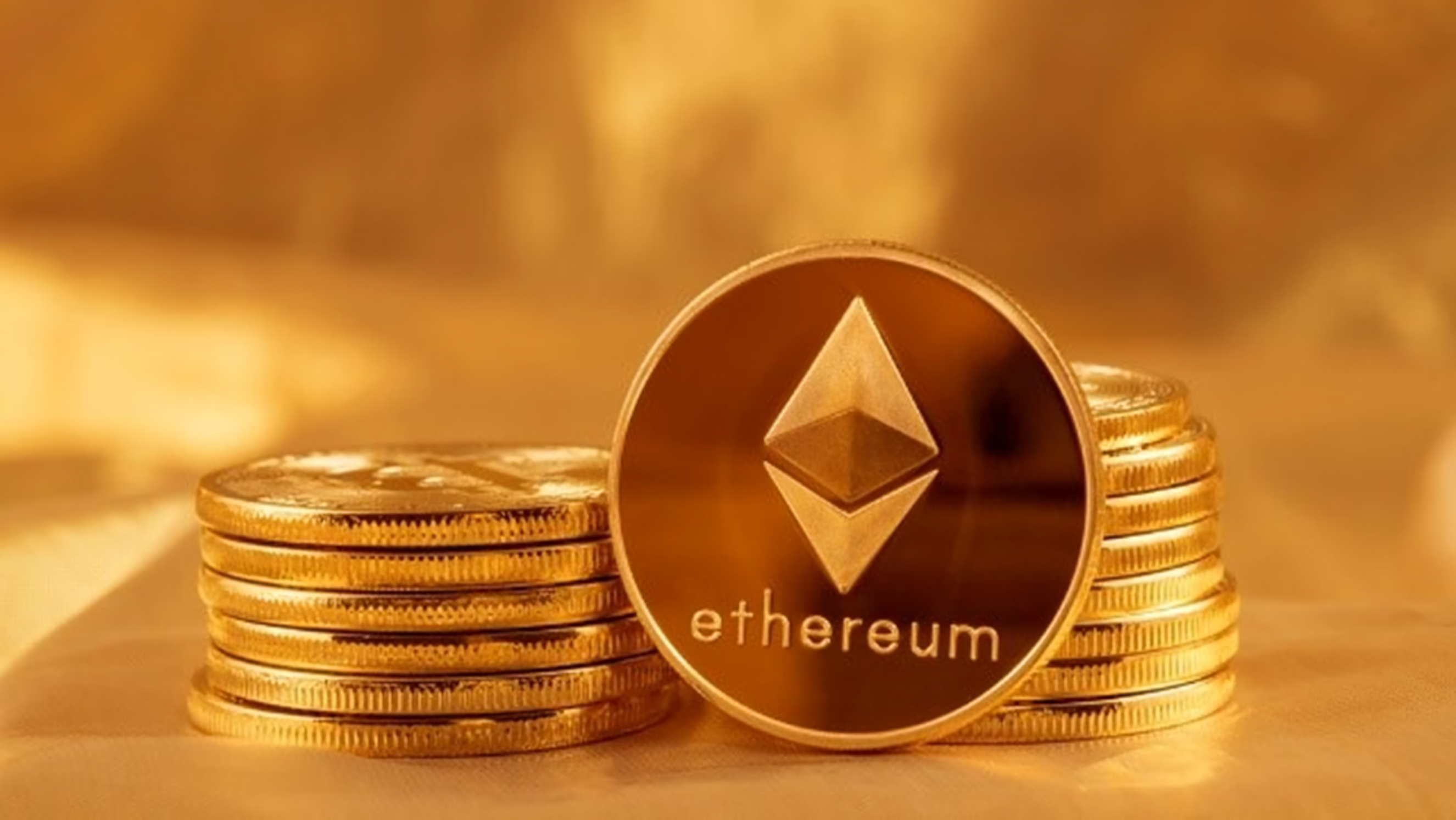 Ethereum-branded gold coins are stacked in two piles, with one coin facing forward displaying the Ethereum logo.